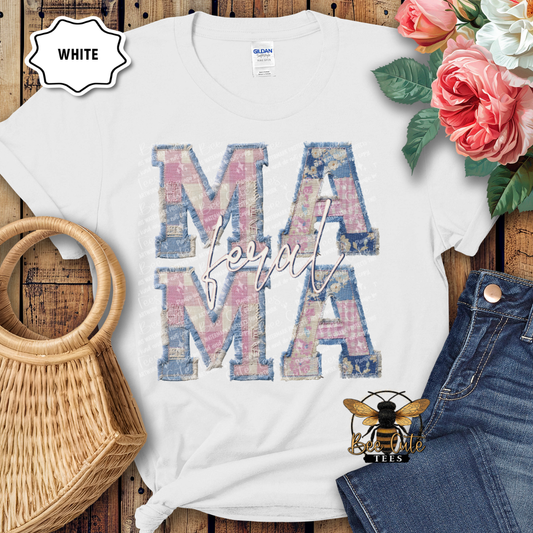 White t-shirt with floral 'MAMA' design on a wooden surface with flowers and denim jeans.