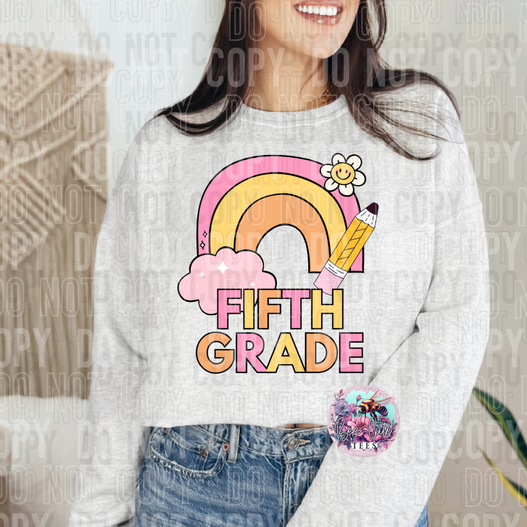 Person wearing a sweatshirt with a rainbow, pencil, and 'Fifth Grade' design.