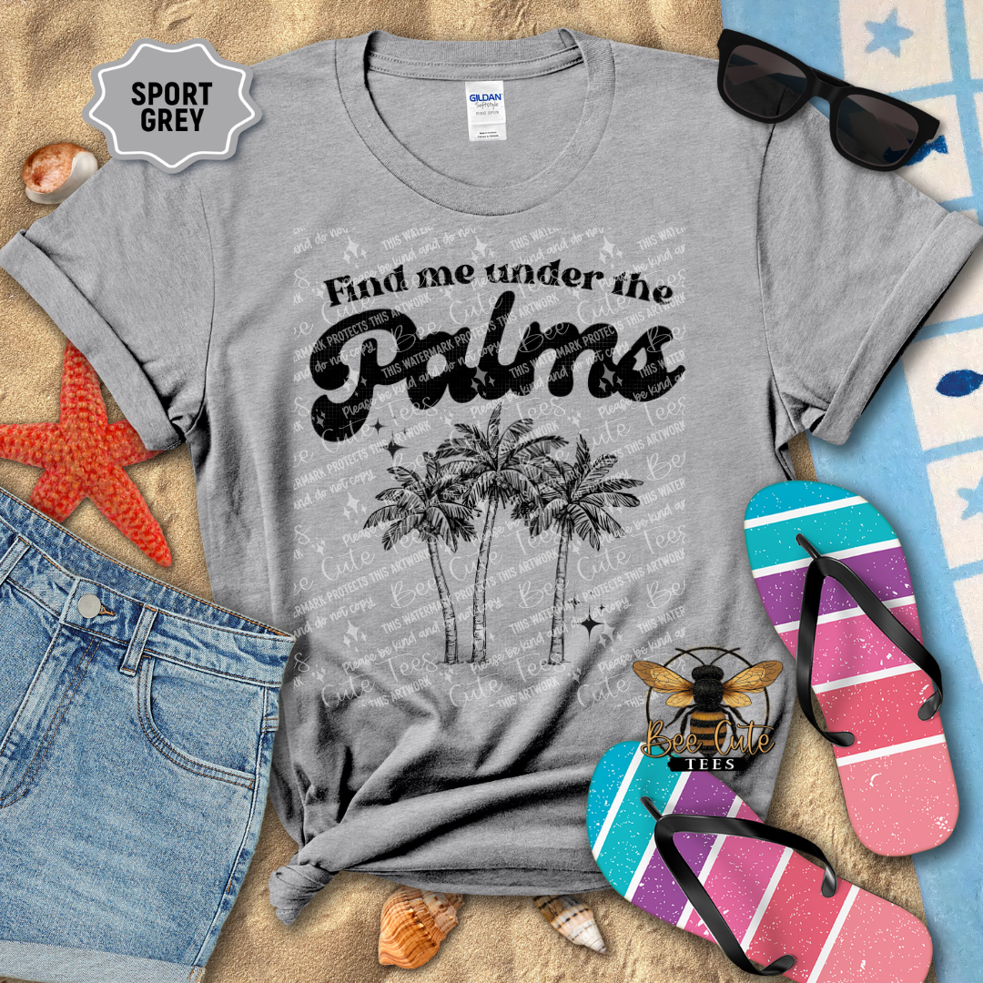 Gray t-shirt with 'Find me under the palms' design on a beach-themed background with sunglasses, flip-flops, and starfish.