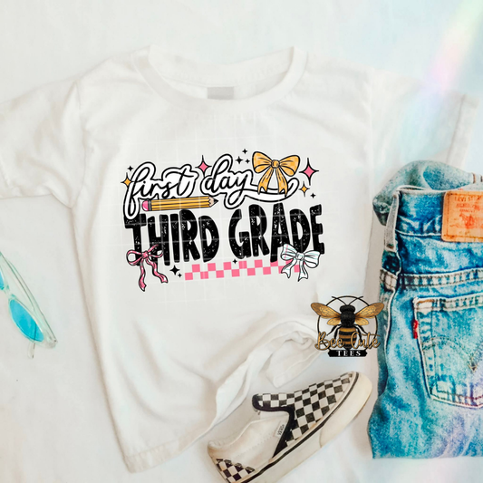 White t-shirt with 'First Day Third Grade' text, denim shorts, and checkered shoes on a white background.