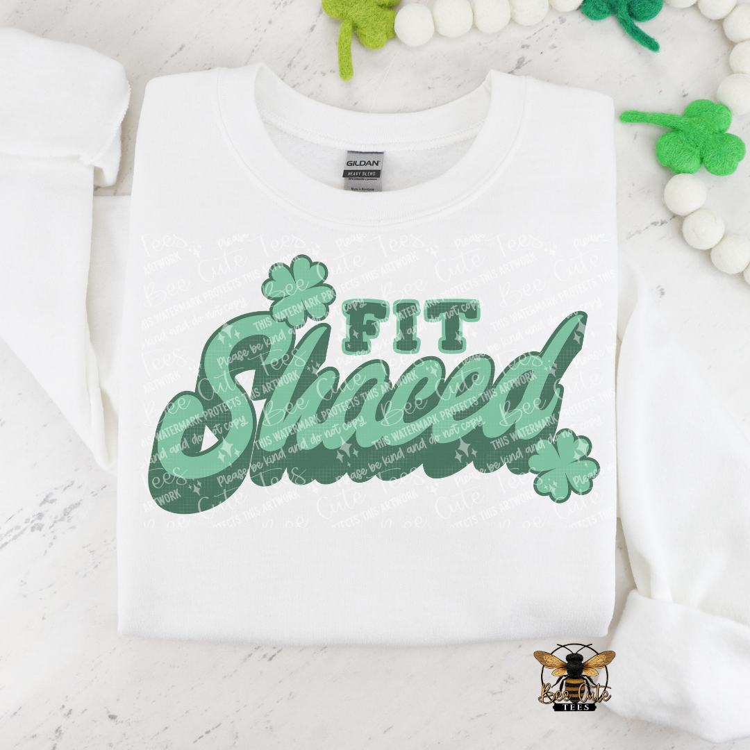 White sweatshirt with green text 'Fit Shaced' on a white background with decorative elements.