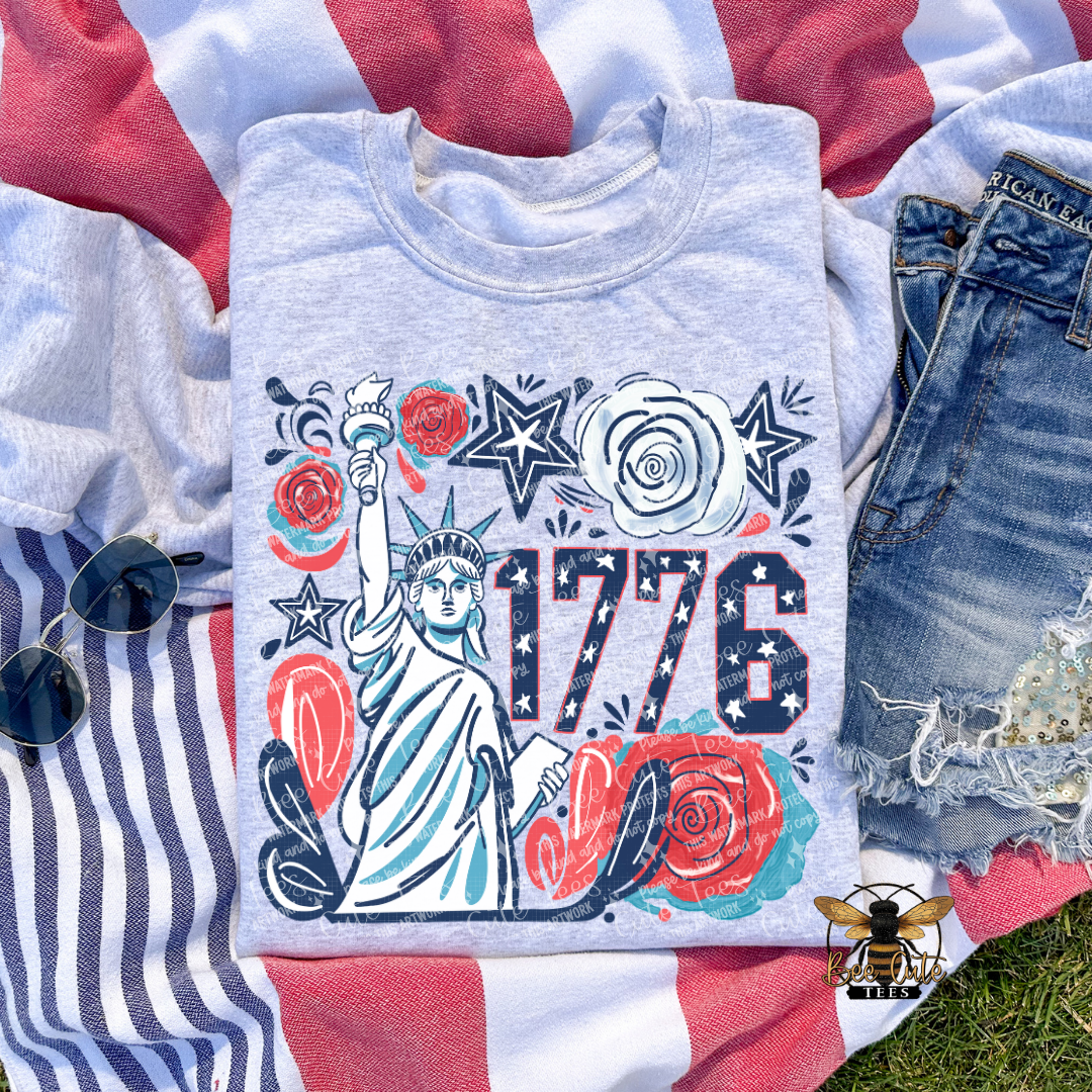 Grey t-shirt with Statue of Liberty and '1776' design on a flag background