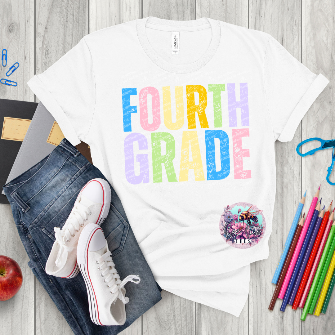 White t-shirt with 'FOURTH GRADE' in colorful letters, paired with jeans, sneakers, and school supplies on a wooden surface.
