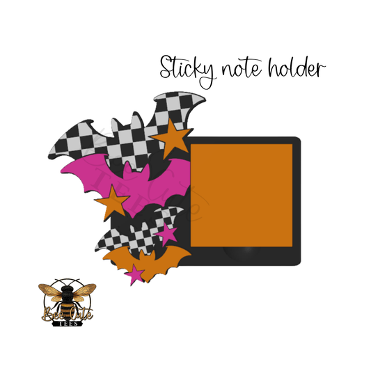 A Halloween-themed sticky note holder featuring bat silhouettes in black-and-white checkered patterns, bright pink bats, orange stars, and small pink stars around a square orange sticky note insert, with the text 'Sticky note holder' above.