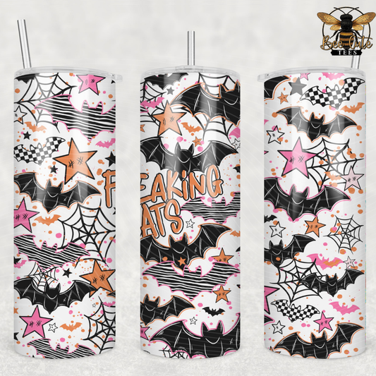 Three tall skinny tumblers with clear straws, shown side by side on a light gray background. The tumblers feature a Halloween-themed print with black bats, pink and orange stars, spiderwebs, clouds, and the words 'FREAKING ATS'.