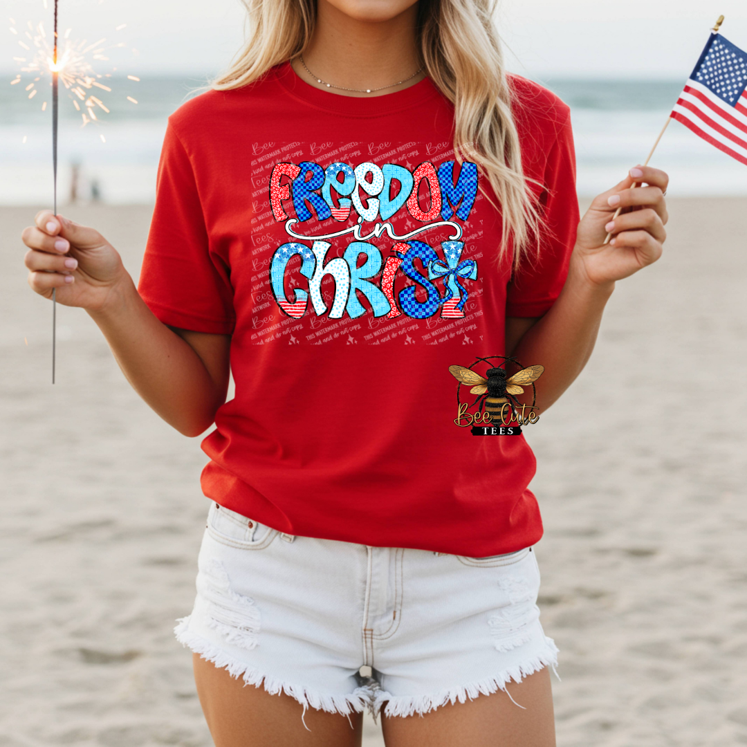Person wearing a red t-shirt with 'Freedom in Christ' on a beach