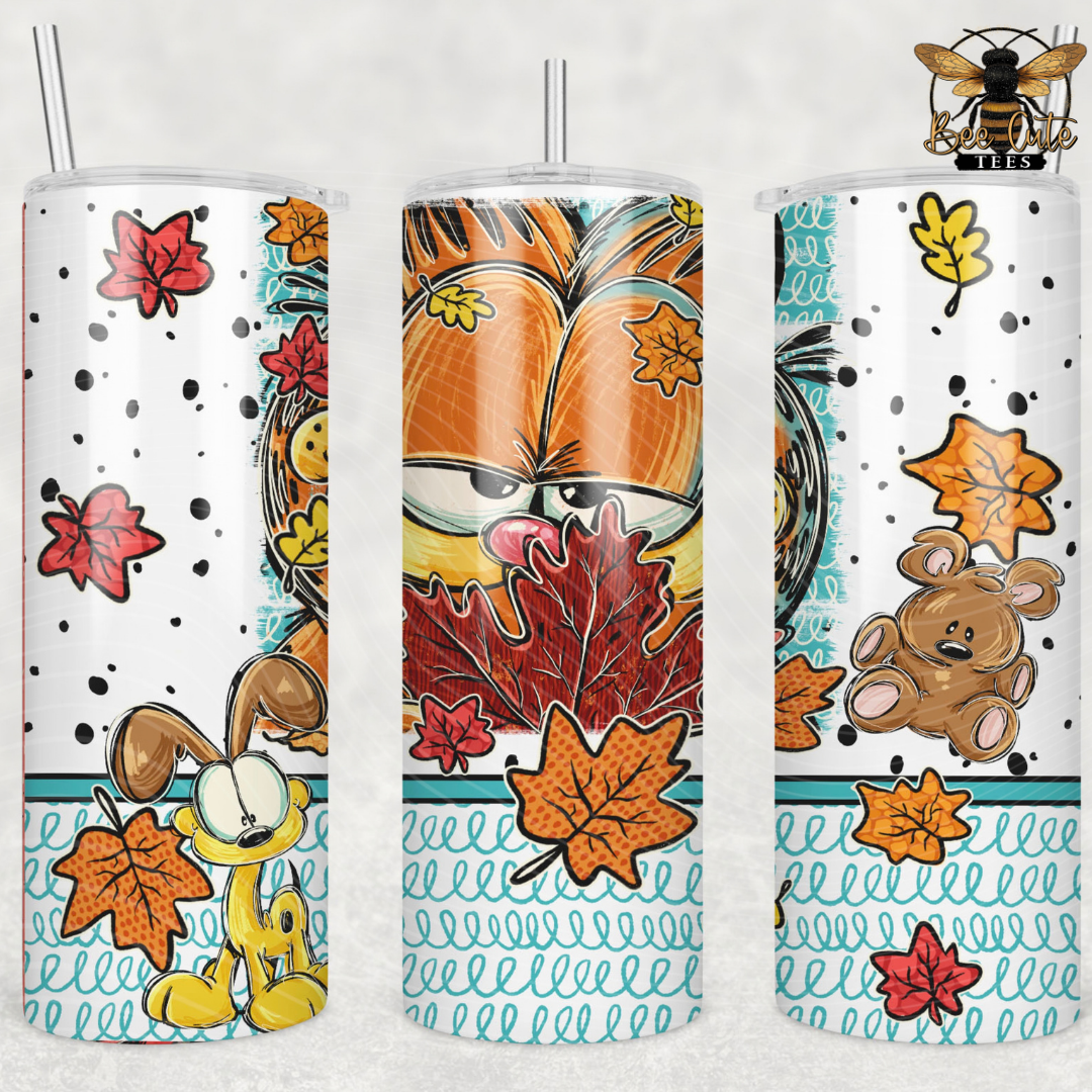 Three views of a tall insulated tumbler with a clear straw, printed with a cat themed autumn graphics including orange leaves, a teddy bear, a yellow cat, and a bee logo on a white background.