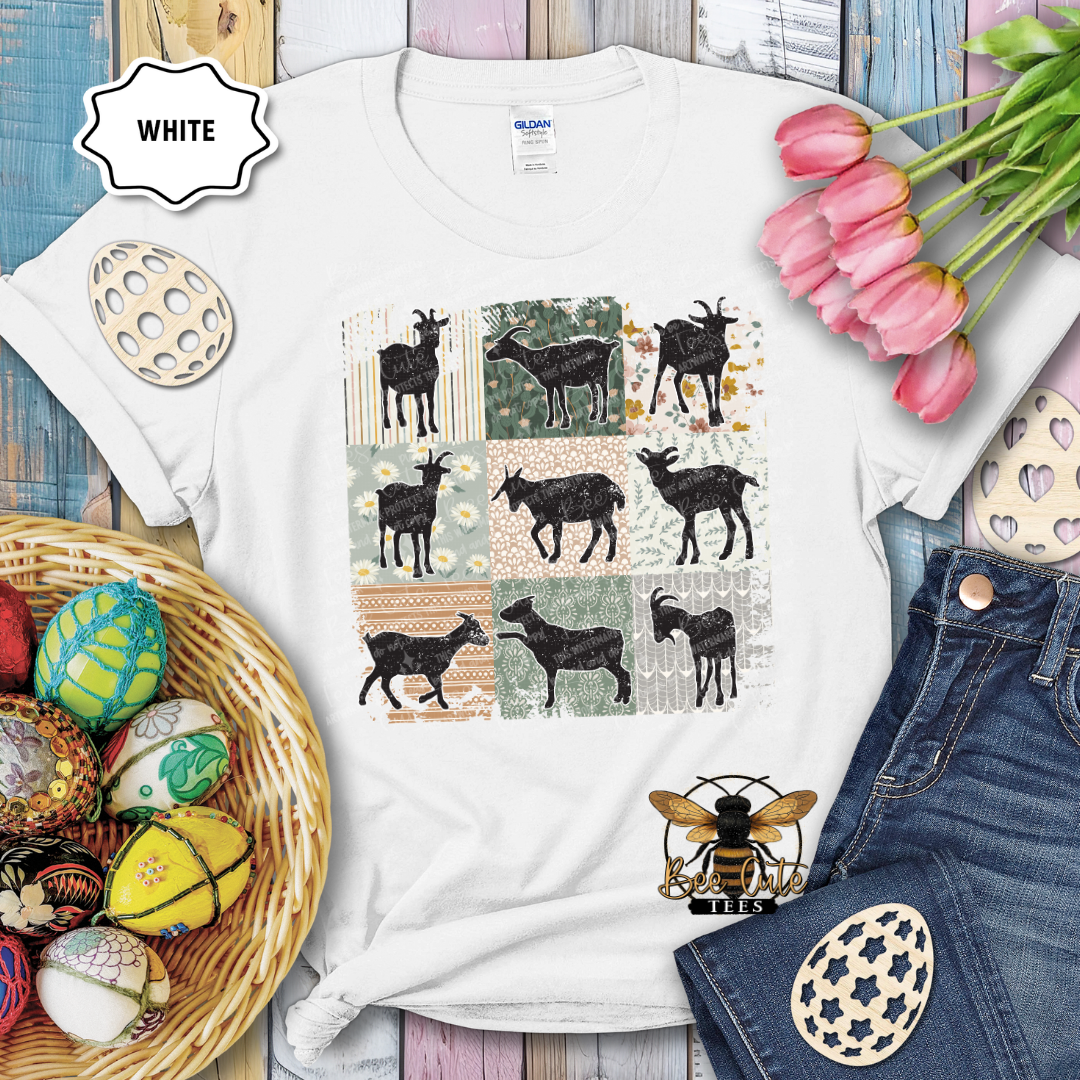 White t-shirt with goat pattern, surrounded by Easter decorations on a wooden surface.
