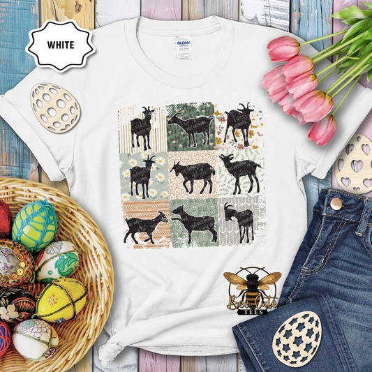 White t-shirt with goat pattern, surrounded by Easter decorations on a wooden surface.