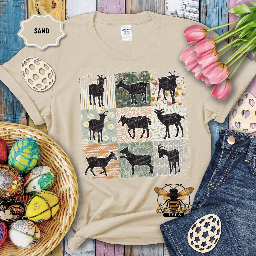 Beige t-shirt with goat pattern, surrounded by decorative items on a wooden surface.