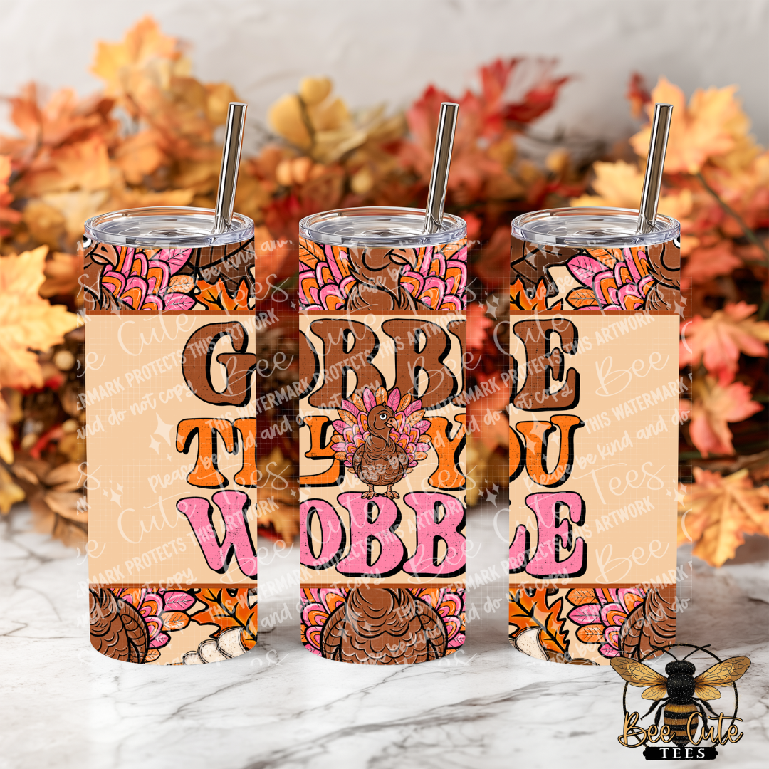 Three insulated tumblers with clear lids and metal straws, decorated with a Thanksgiving theme and the words “Grabb the Cobbler,” shown on a marble surface with autumn leaves in the background.