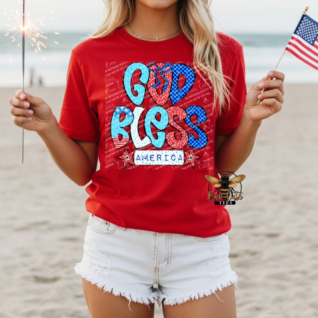Person wearing a red t-shirt with 'God Bless America' on a beach