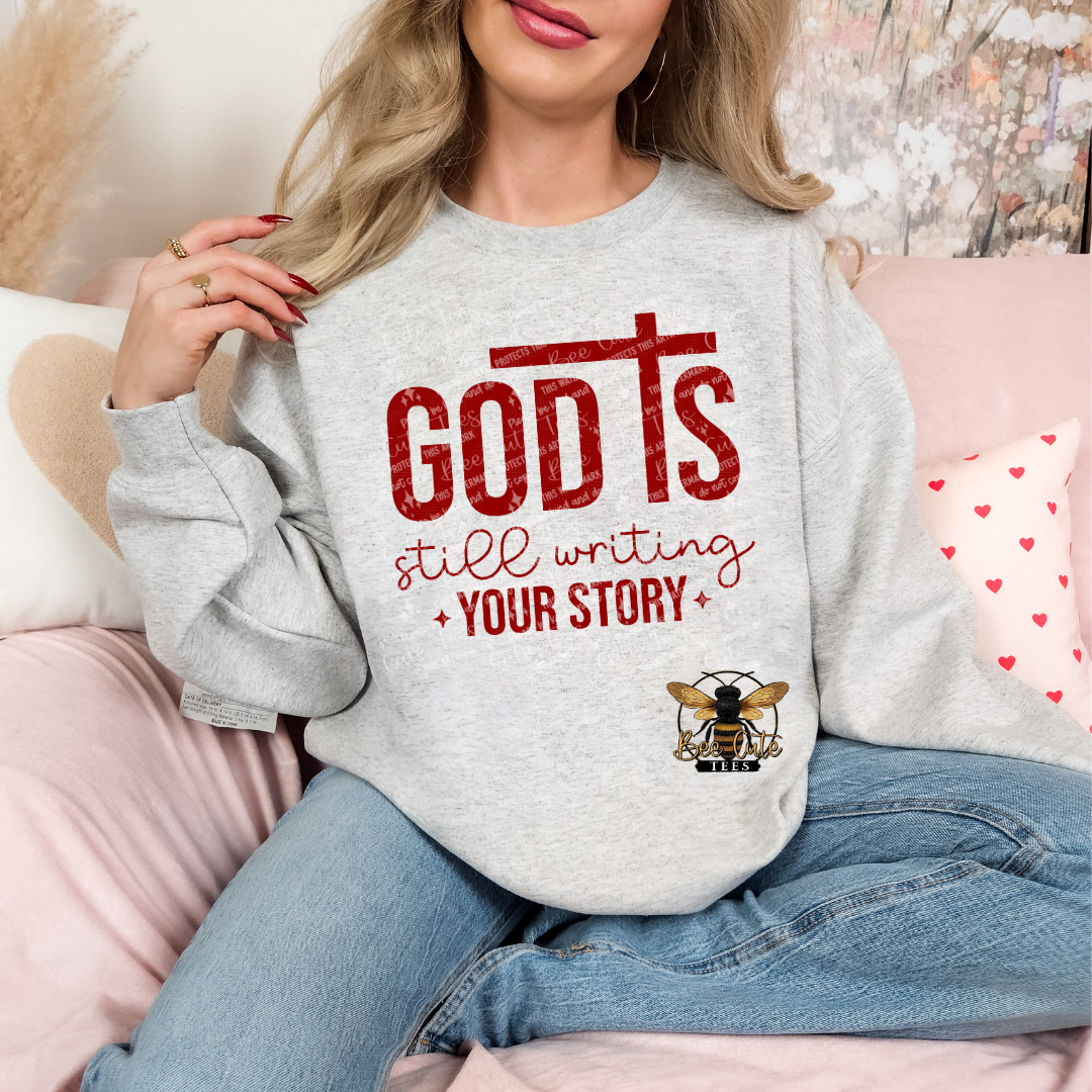 Person wearing a gray sweatshirt with red text and a graphic, sitting on a couch.