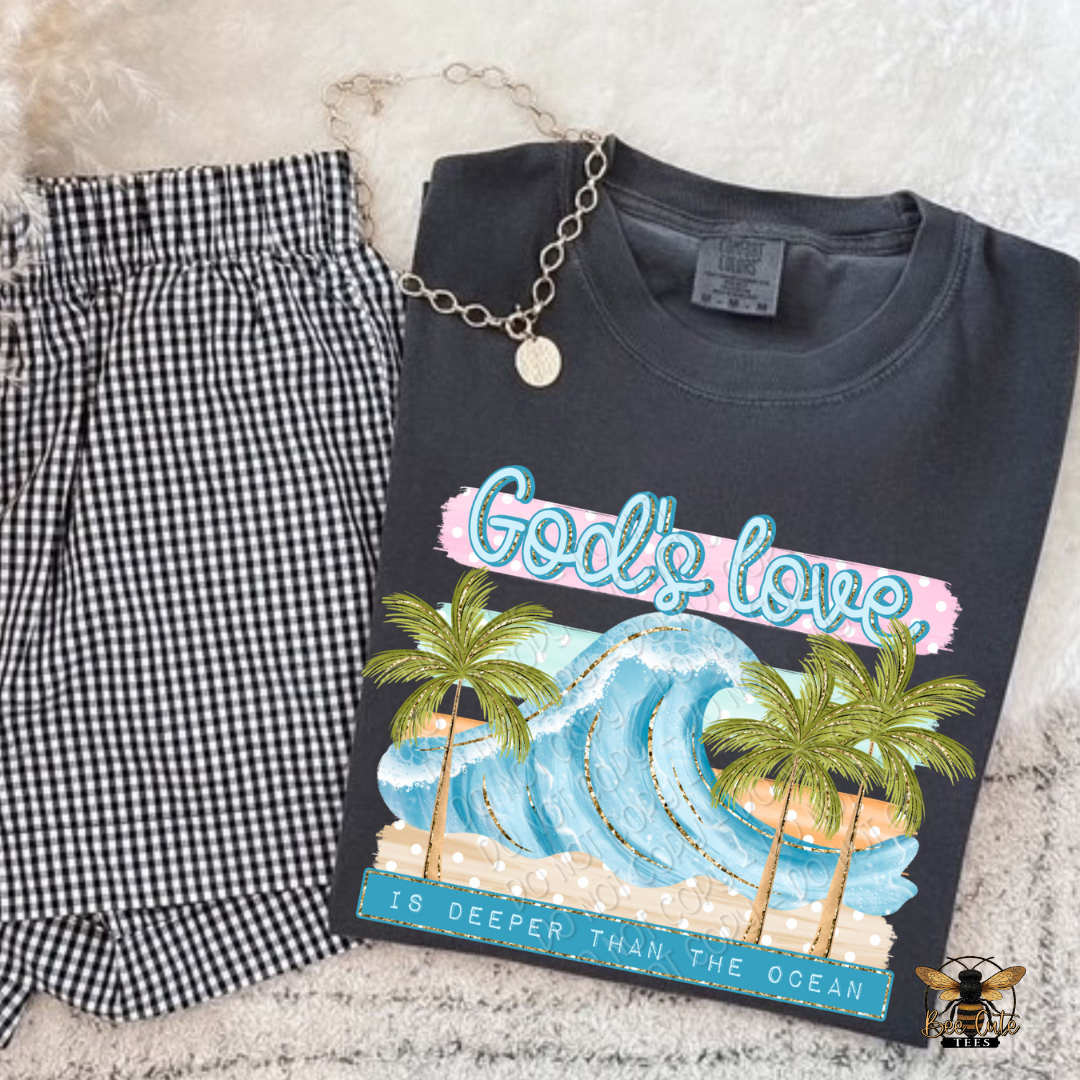 Black t-shirt with ocean and palm tree design and checkered shorts on a textured surface