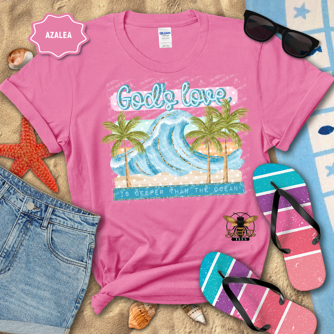 Pink t-shirt with beach graphic and sunglasses, flip-flops, and denim shorts on a sandy background.