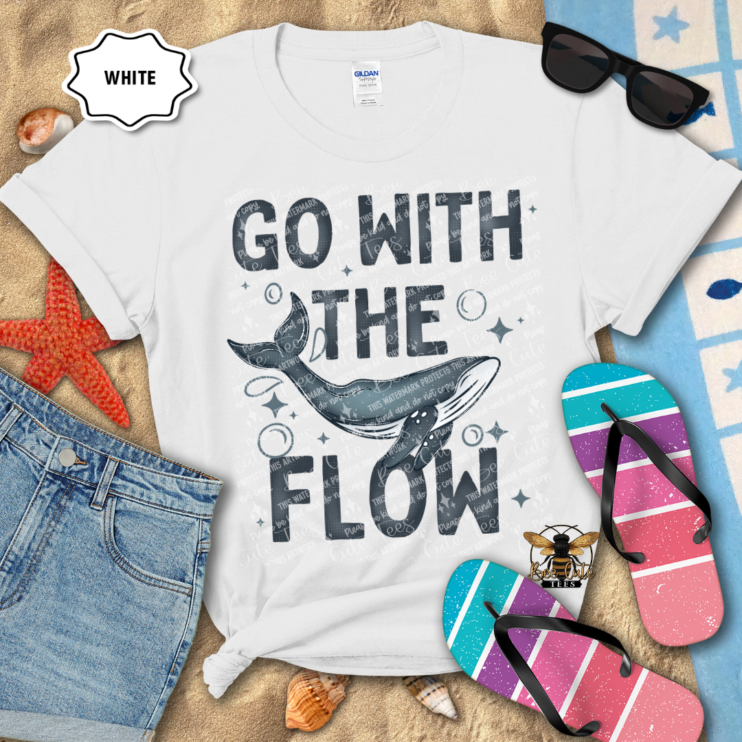 White t-shirt with 'Go with the Flow' design on a beach-themed background with sunglasses, flip-flops, and denim shorts.