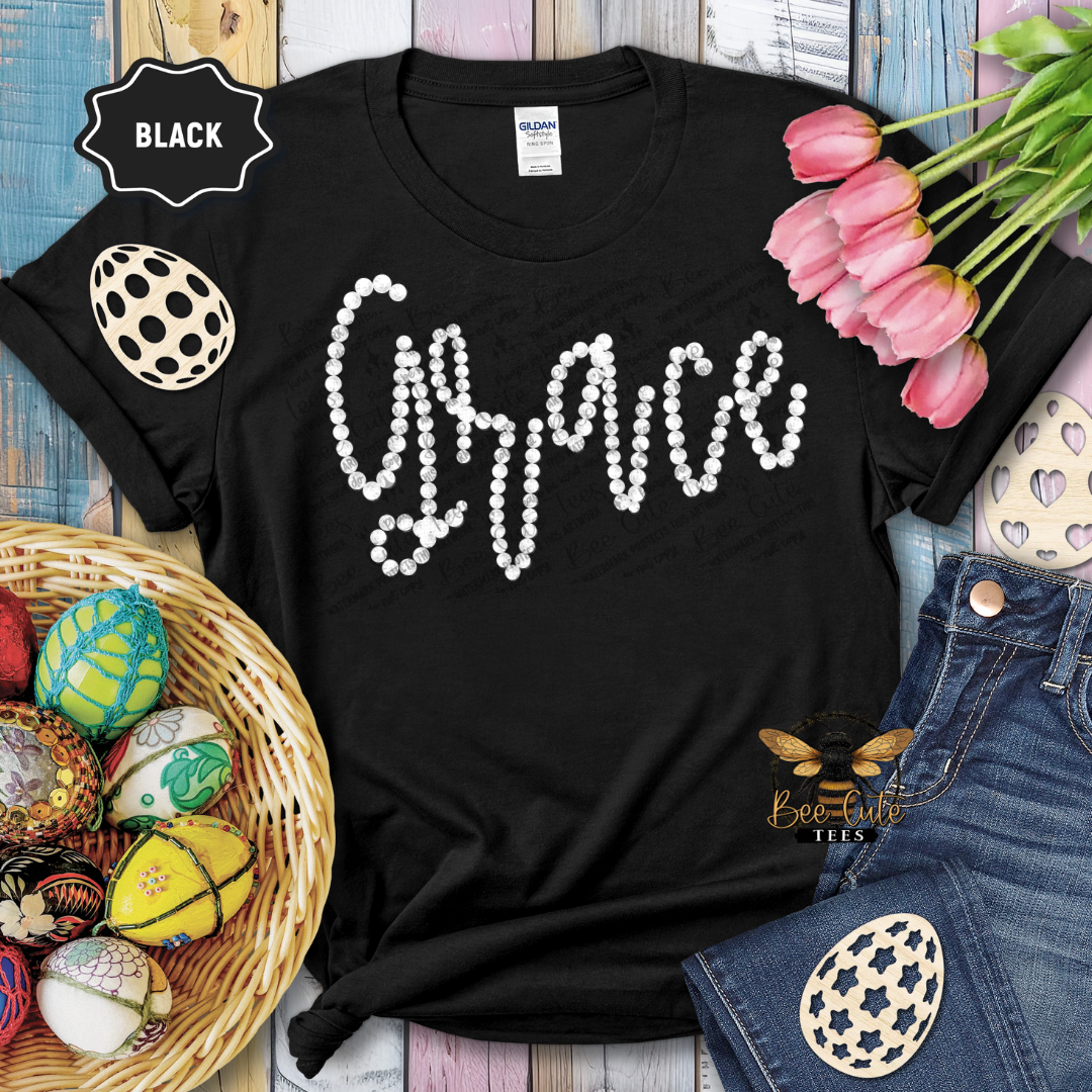 Black t-shirt with 'Grace' design on a wooden surface with tulips and decorative eggs.