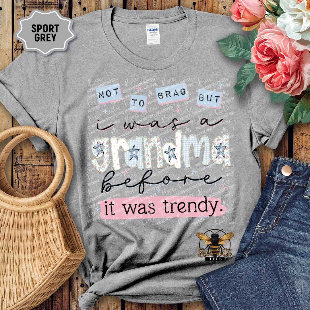 Gray t-shirt with humorous text design on a wooden surface with flowers and jeans.