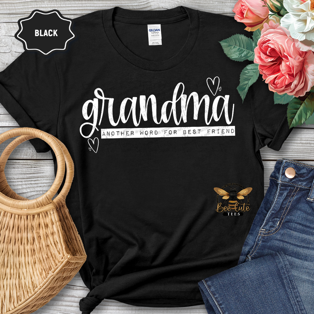Black t-shirt with 'grandma another word for best friend' text, surrounded by flowers and jeans on a wooden surface.