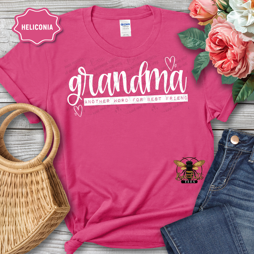 Pink t-shirt with 'grandma' text, surrounded by flowers and accessories on a wooden surface.