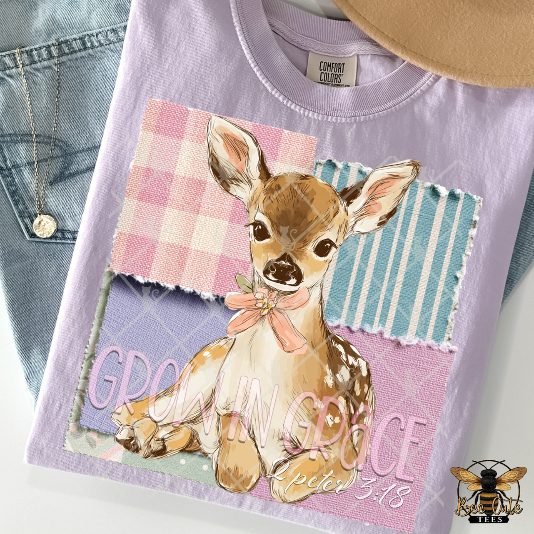Purple t-shirt with a deer graphic and 'In Grace' text, displayed with denim jeans and a hat.