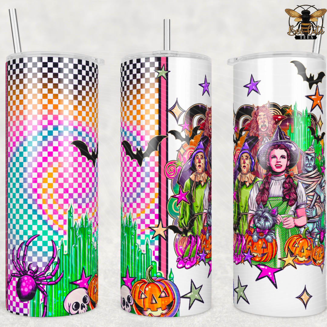 Three clear tumblers with clear straws shown side by side, each featuring a colorful Halloween-themed printed design. The designs include a checkerboard rainbow background, bats, spiders, pumpkins, stars, and illustrated characters in green and purple tones.