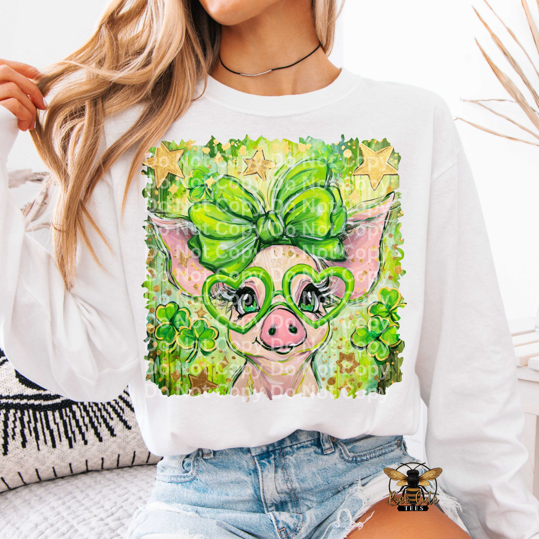 Person wearing a white sweatshirt with a colorful pig design featuring green glasses and a bow.