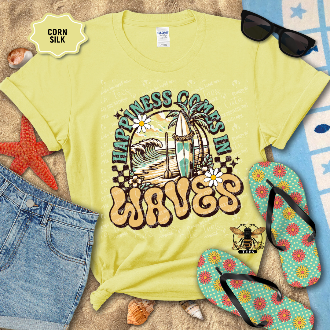 Yellow t-shirt with 'Happiness Comes in Waves' design on a beach-themed background with sunglasses, flip-flops, and starfish.