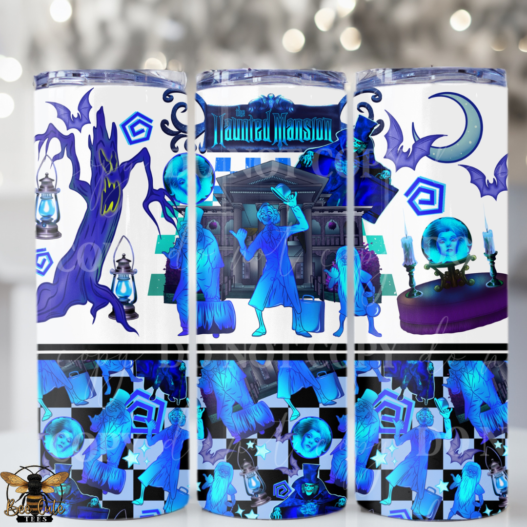 Three tall skinny tumblers with clear lids, wrapped in a Halloween-themed wrap design featuring blue and purple haunted house motifs, ghosts, bats, lanterns, and the words 'Haunted Mansion.' The tumblers are shown against a softly blurred festive background with bokeh lights.