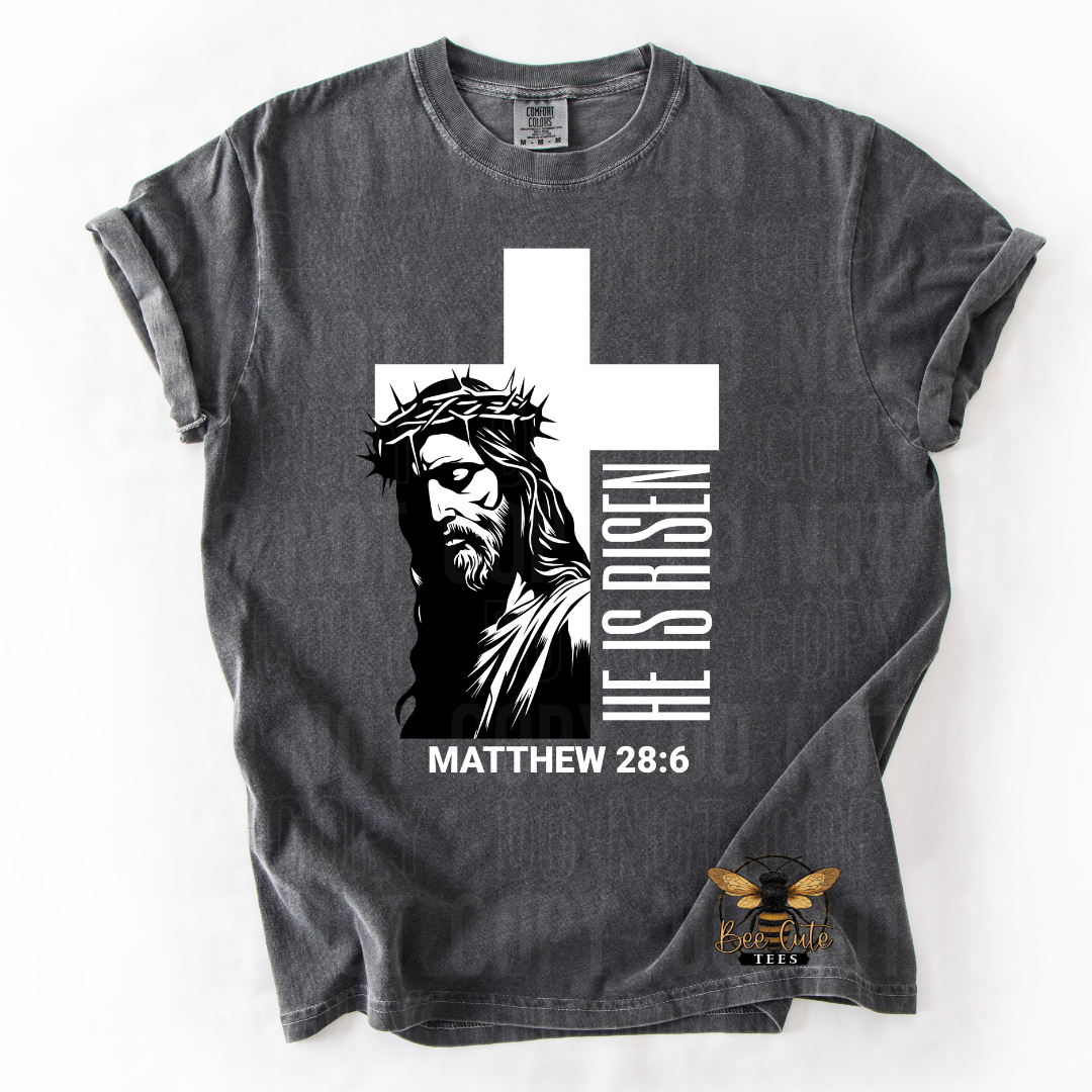 Gray t-shirt with Jesus graphic and 'He is Risen' text on a white background