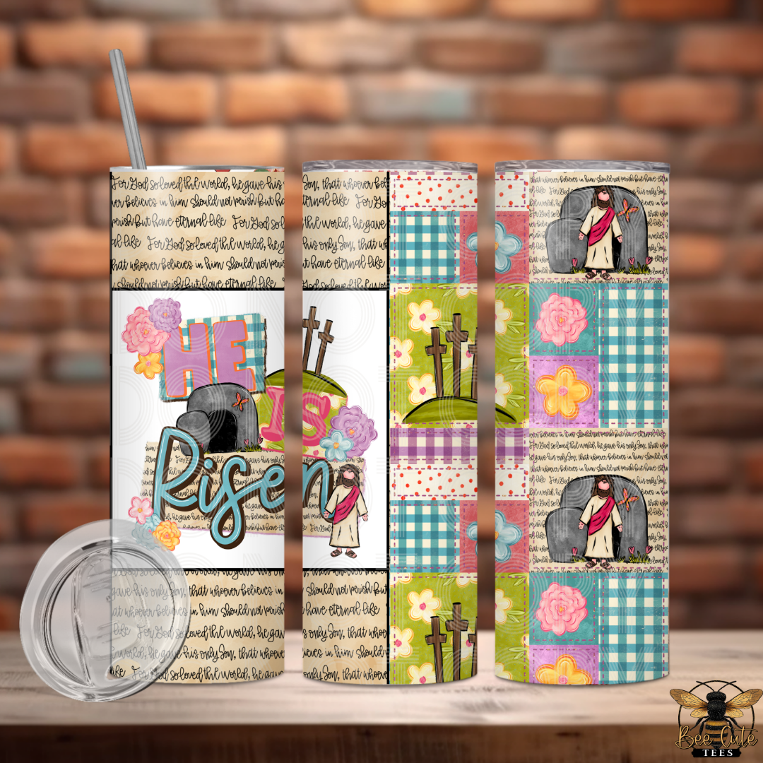 Set of three colorful tumblers with religious designs on a wooden surface against a brick wall background.