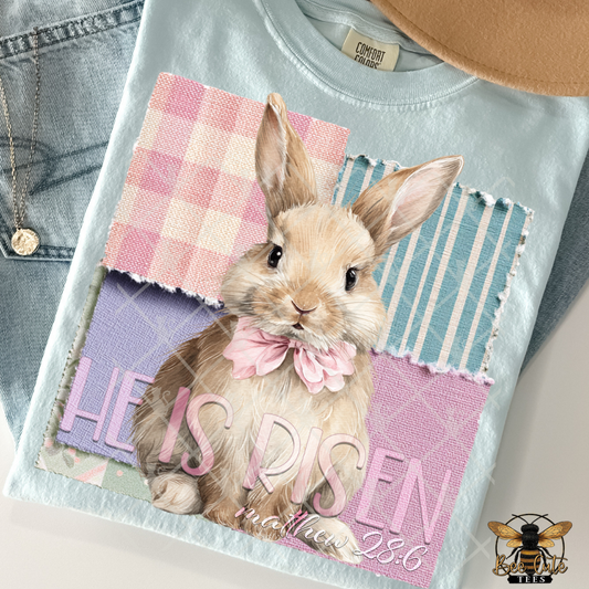 T-shirt with a rabbit graphic and 'He is Risen' text on a checkered background