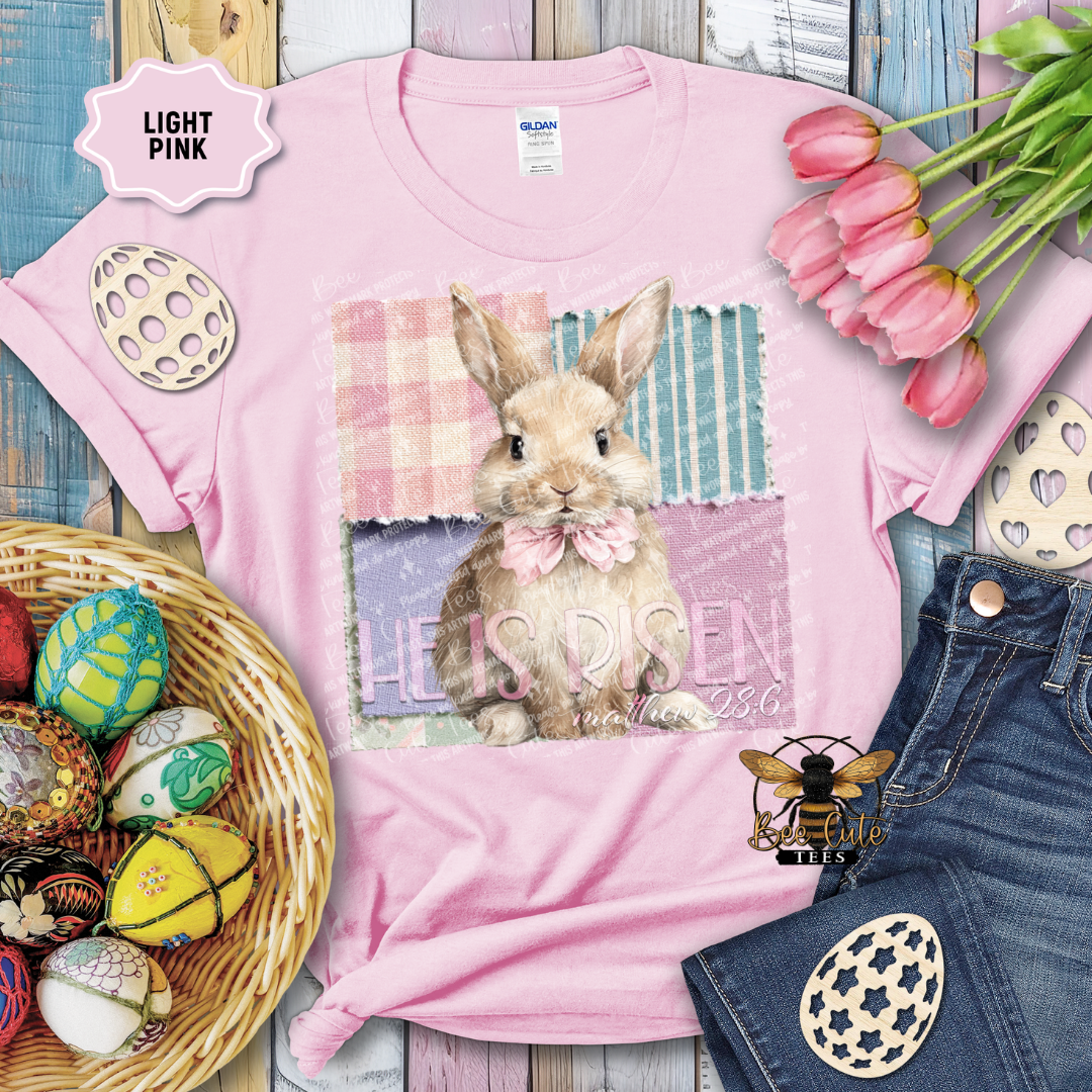 Pink t-shirt with a bunny graphic and Easter decorations on a wooden surface