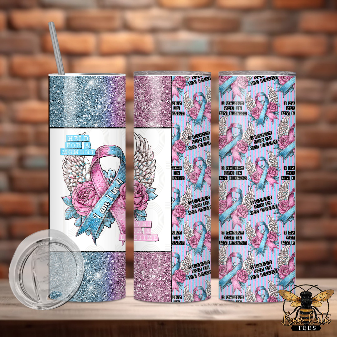 Three views of a 20 oz pregnancy and infant loss awareness tumbler featuring pink and blue awareness ribbons, angel wings, pink roses, and glitter-look accents in pink, blue, and purple. The front design includes the phrases “Held for a Moment” and “Loved for a Lifetime,” with “I Am 1 in 4” written across the ribbon. The repeating back design features pink and blue ribbons, roses, angel wings, and the heartfelt phrase “I Carry You in My Heart” against a pink and blue striped background.