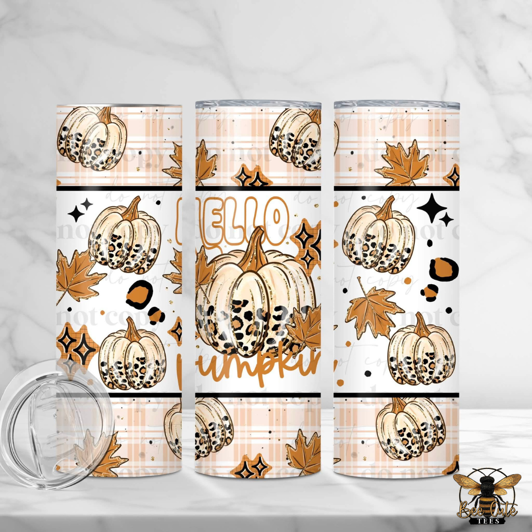 Three insulated tumblers with a fall-themed pumpkin print are displayed on a white marble surface with a marble background. The print features beige pumpkins with black spots, brown maple leaves, and the words 'Hello Pumpkin' in gold.
