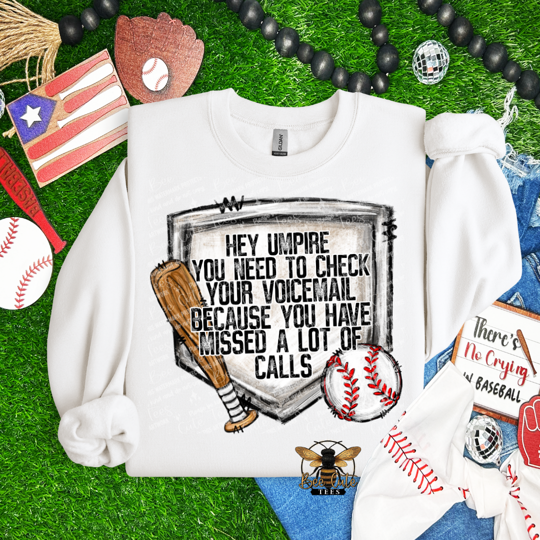White sweatshirt with a humorous baseball-themed graphic on a grassy background with sports-themed accessories.