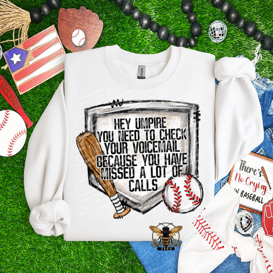 White sweatshirt with a humorous baseball-themed graphic on a grassy background with sports-themed accessories.