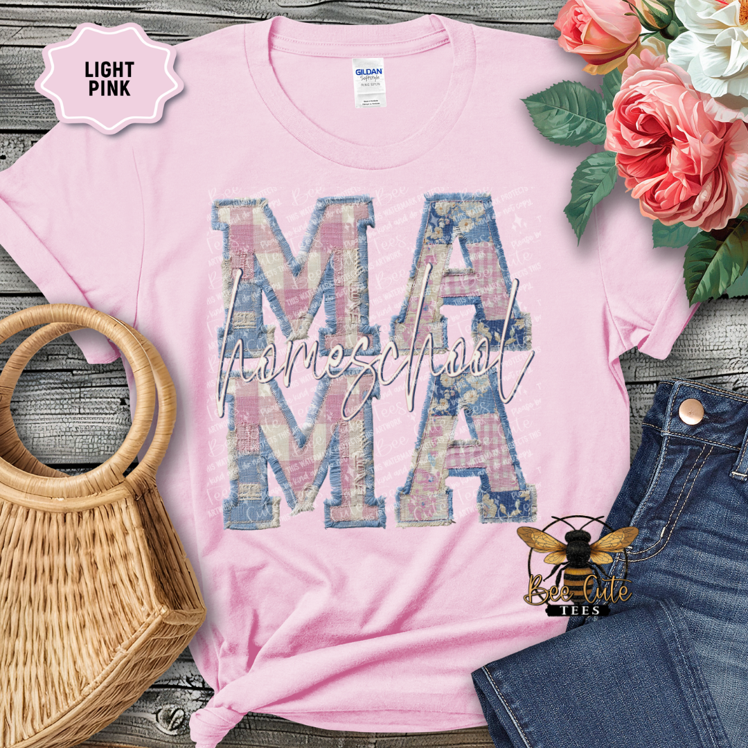 Light pink t-shirt with 'MAMA' print, surrounded by flowers and denim jeans on a wooden surface.