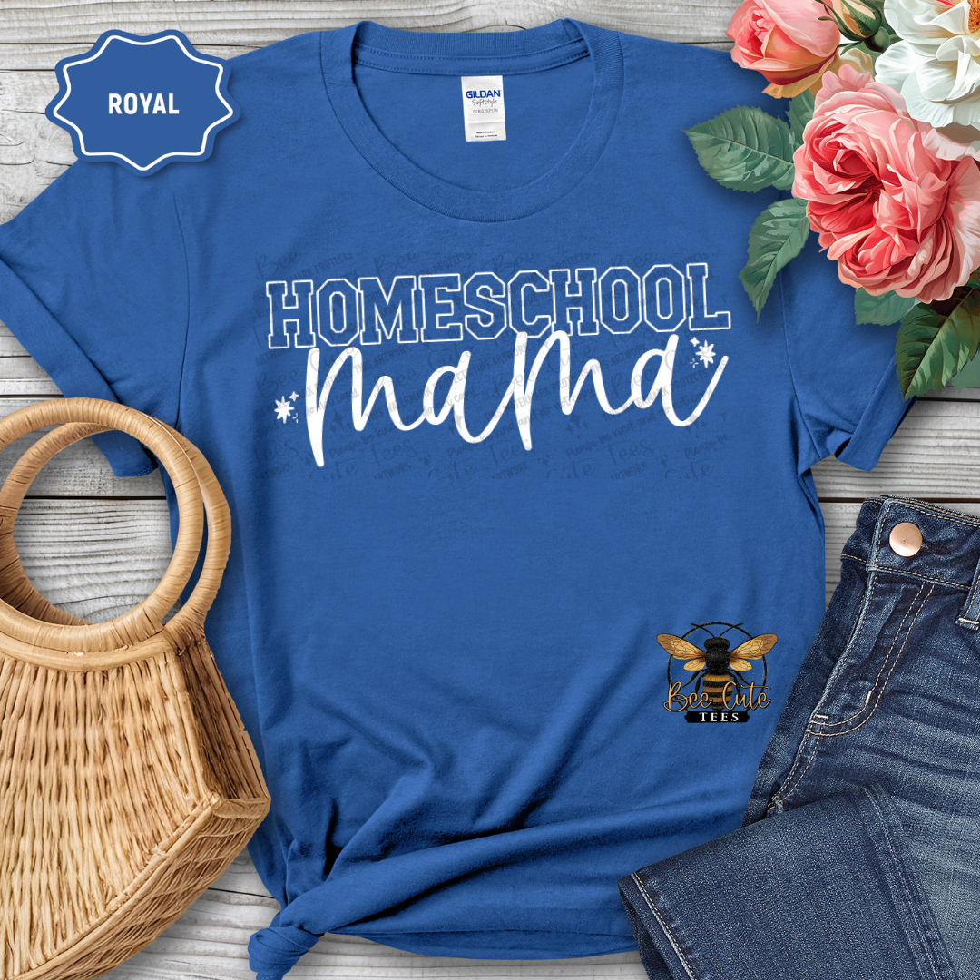 Blue t-shirt with 'Homeschool Mama' text and a logo, surrounded by flowers and jeans on a wooden surface.