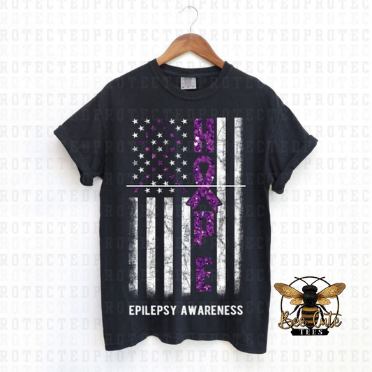 Black t-shirt with epilepsy awareness design featuring an American flag and purple ribbon on a white background.