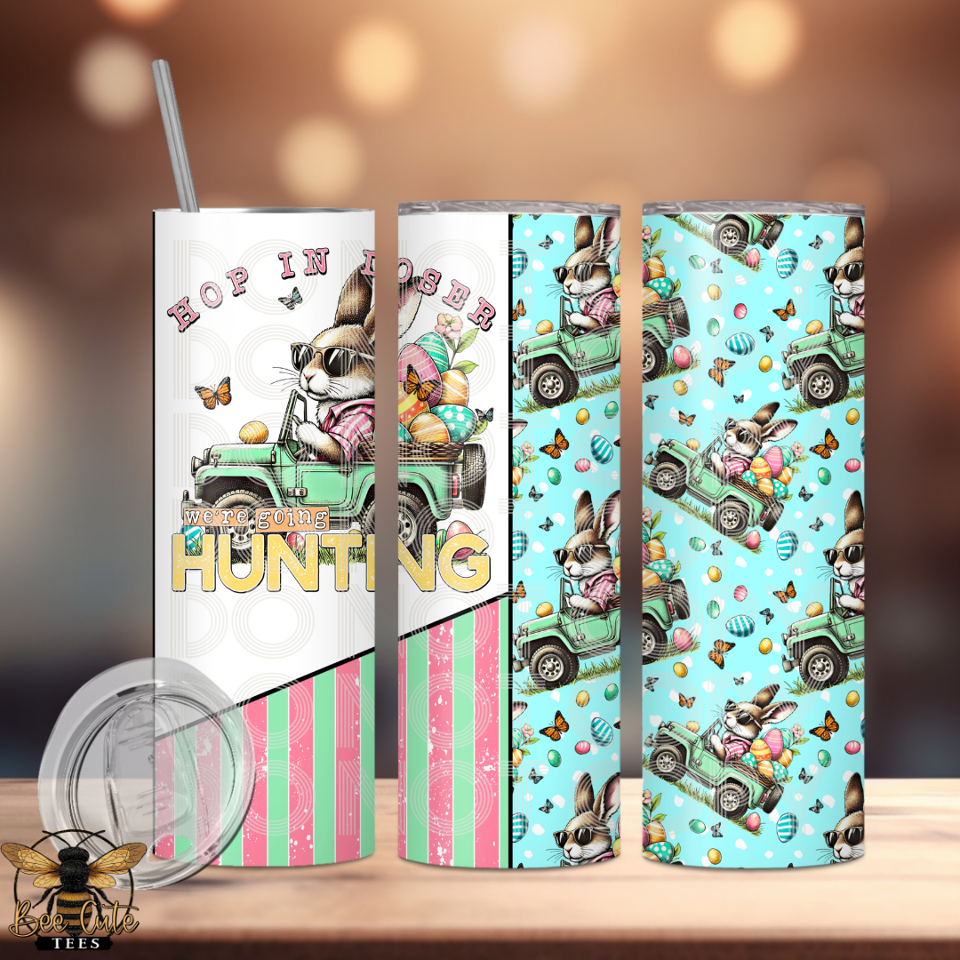 20 oz stainless steel tumbler featuring a fun Easter bunny driving a truck with colorful eggs, “Hop in loser, we’re going hunting” text, and a playful mix of pastel stripes and patterned background; includes lid and straw.
