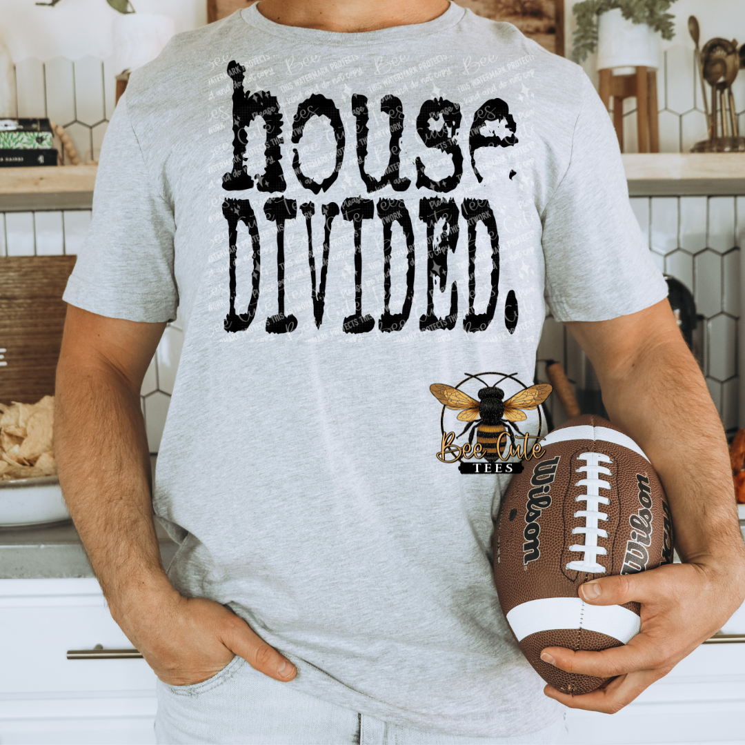 Sport grey graphic t-shirt featuring distressed black “house divided.” text, shown on a model holding a football in a casual, game day setting.
