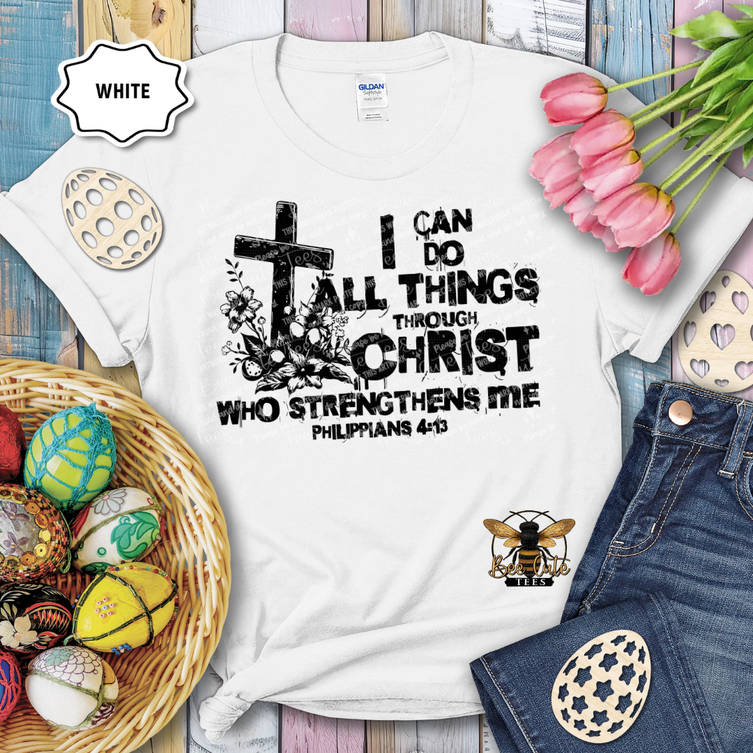 White t-shirt with motivational quote, surrounded by Easter decorations on a wooden surface.