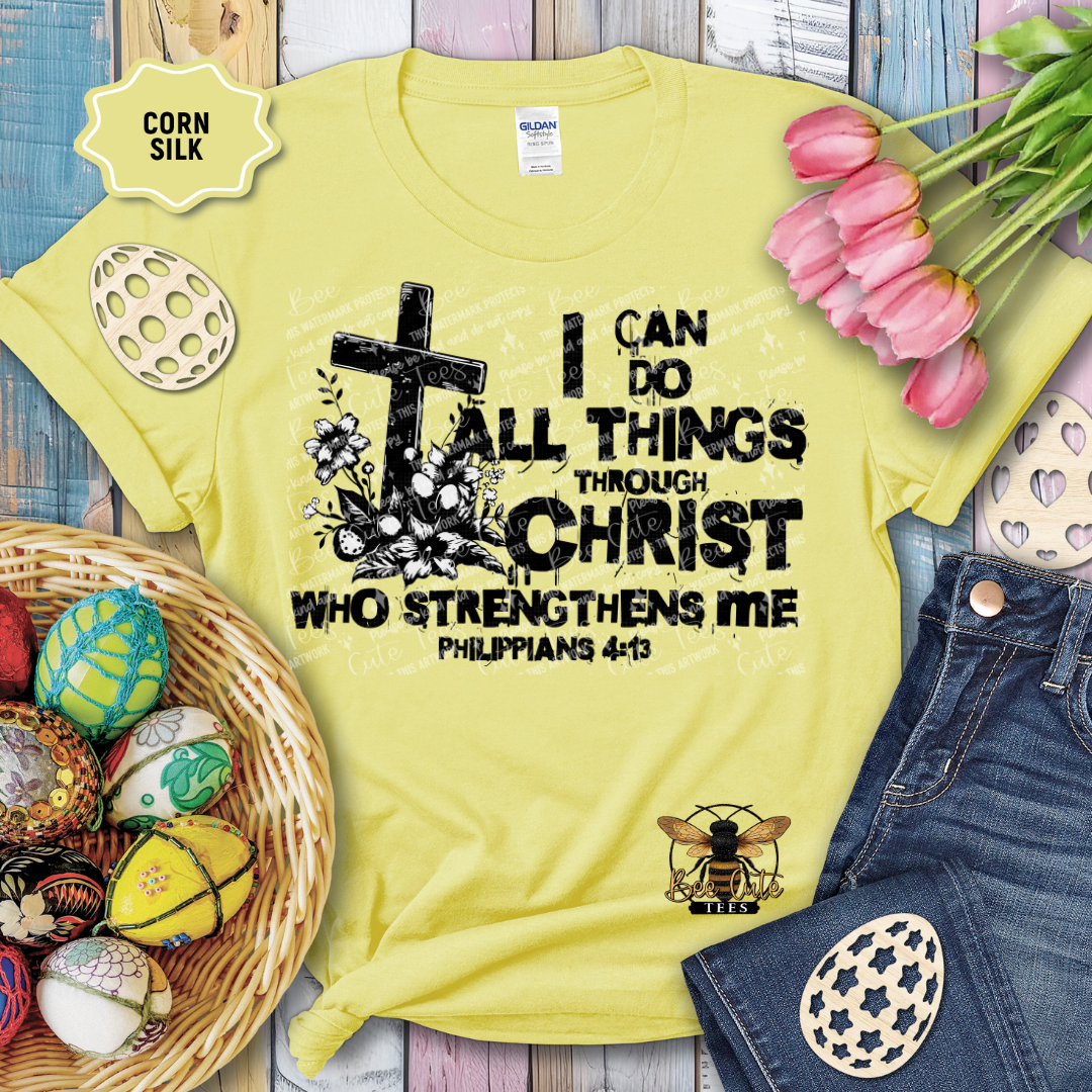 Yellow t-shirt with religious quote and cross design, surrounded by Easter decorations on a wooden surface.