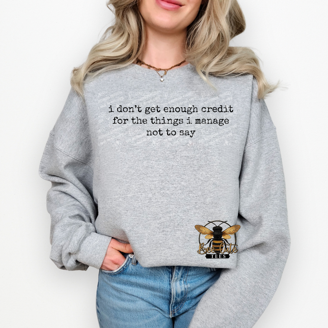 Person wearing a gray sweatshirt with text and a logo on a white background