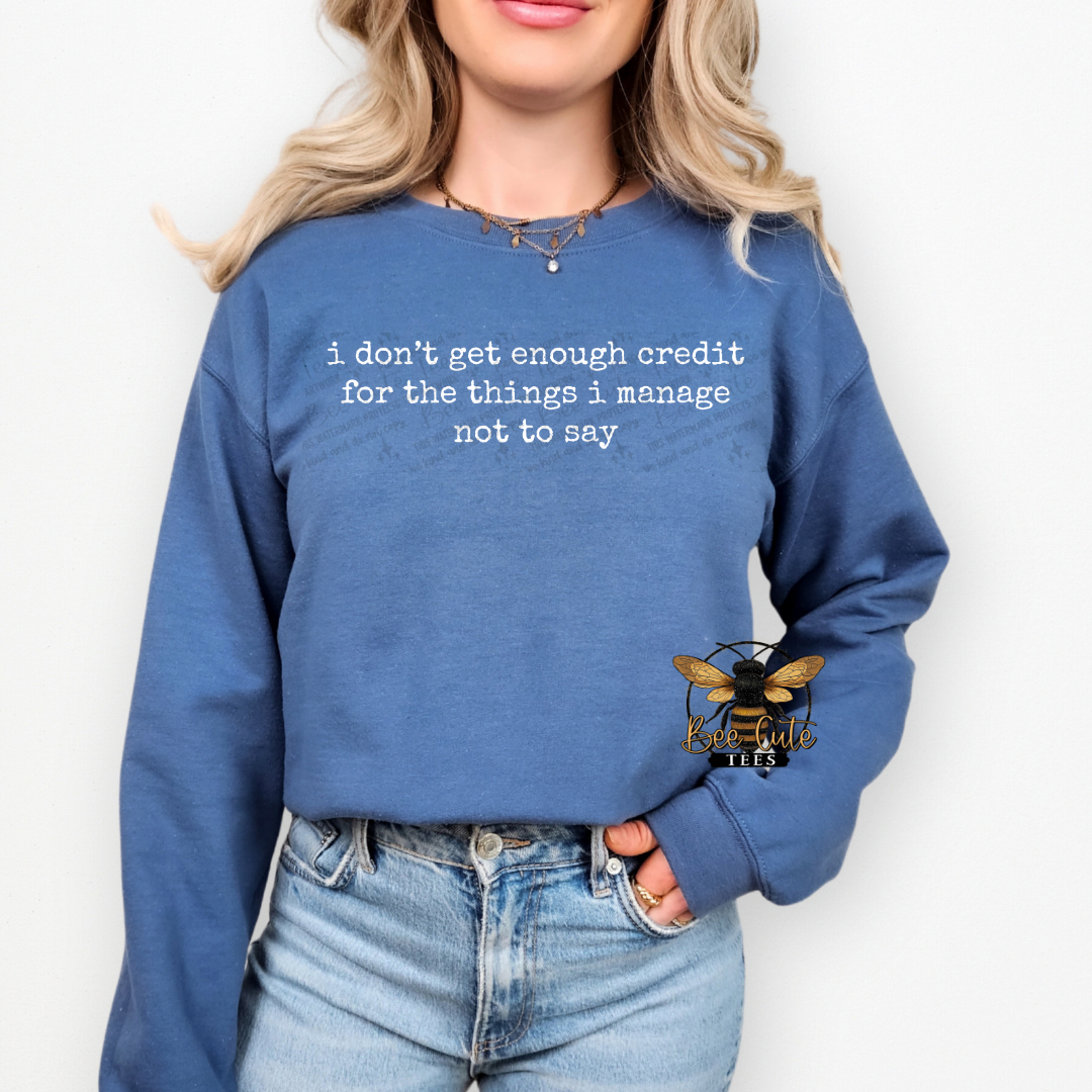 Person wearing a blue sweatshirt with text and a logo on a white background