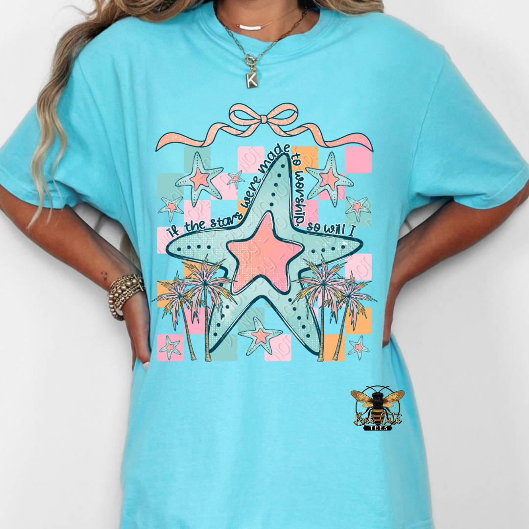 Person wearing a turquoise t-shirt with a colorful star design and text.
