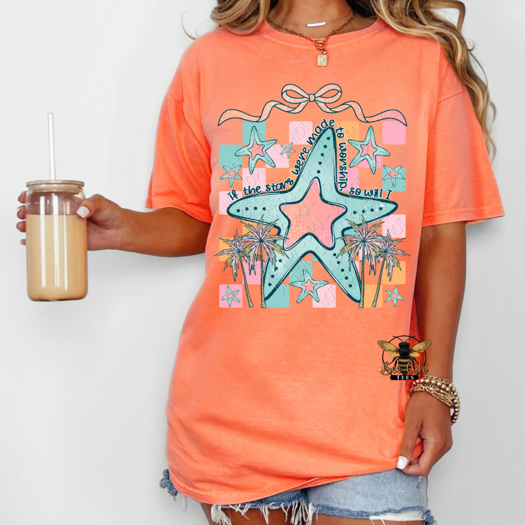 Person wearing an orange t-shirt with a starfish design, holding a drink.