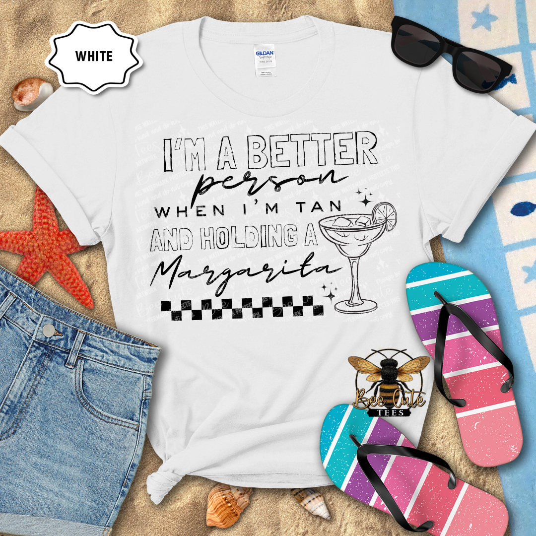 White t-shirt with humorous text design on a beach-themed background with sunglasses, flip-flops, and denim shorts.