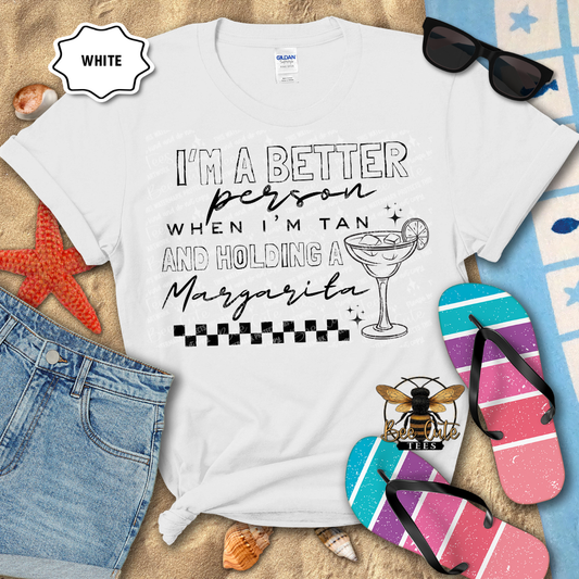 White t-shirt with humorous text design on a beach-themed background with sunglasses, flip-flops, and denim shorts.